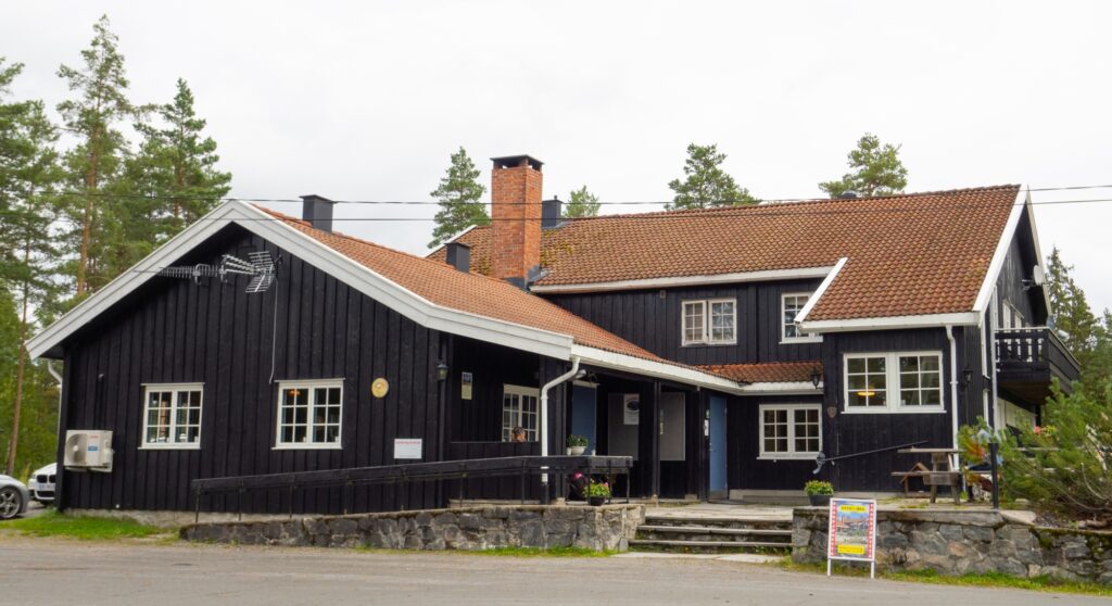 Hele dragsjøhytta en høst dag, med trær i bakgrunnen.